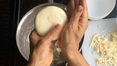 Alisar con aceite la masa de arepas con queso