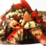 Ensalada de tomate y mozzarella con salsa de albahaca y piñones